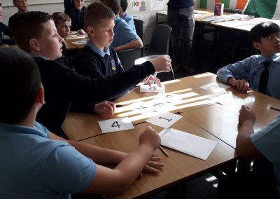 Students sitting at a desk working on a language game